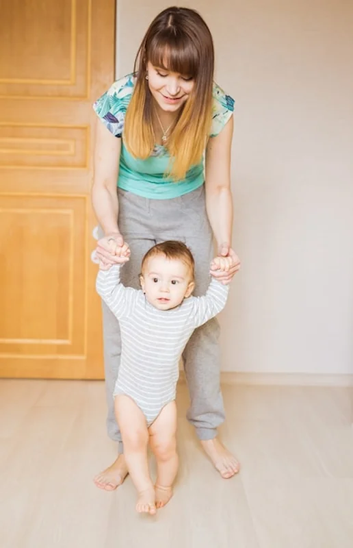 Małe dziecko uśmiechające się, robiące pierwsze kroki