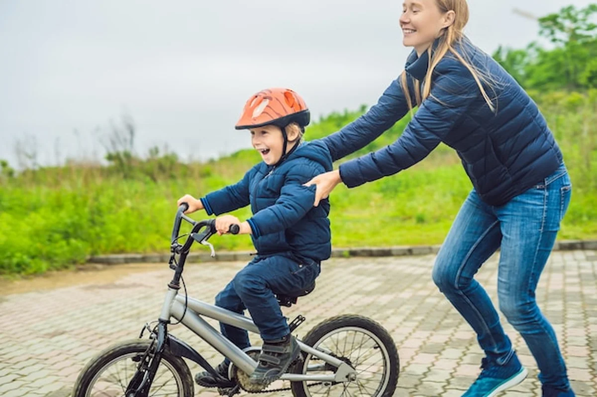 Mama uczy syna jeździć na rowerze w parku