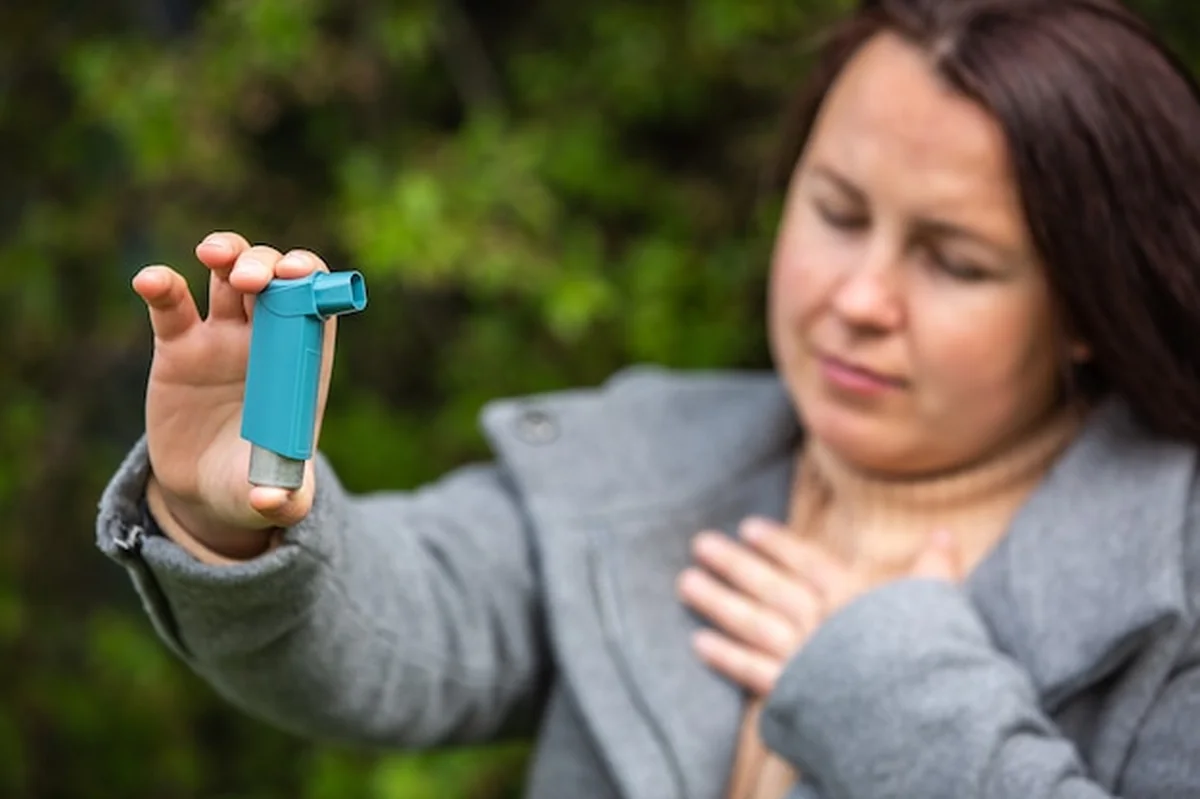 Kobieta z astmą trzyma inhalator