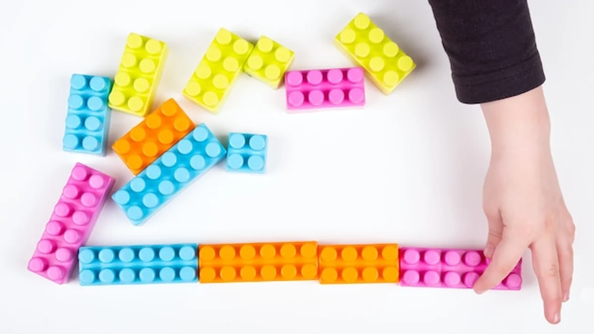 Dziecko bawi się konstruktorem na białej powierzchni