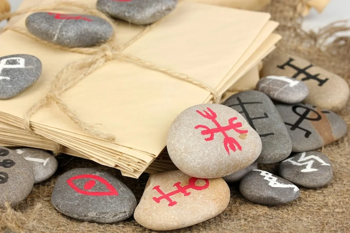 Wróżenie z symbolami na kamieniach na tle juty