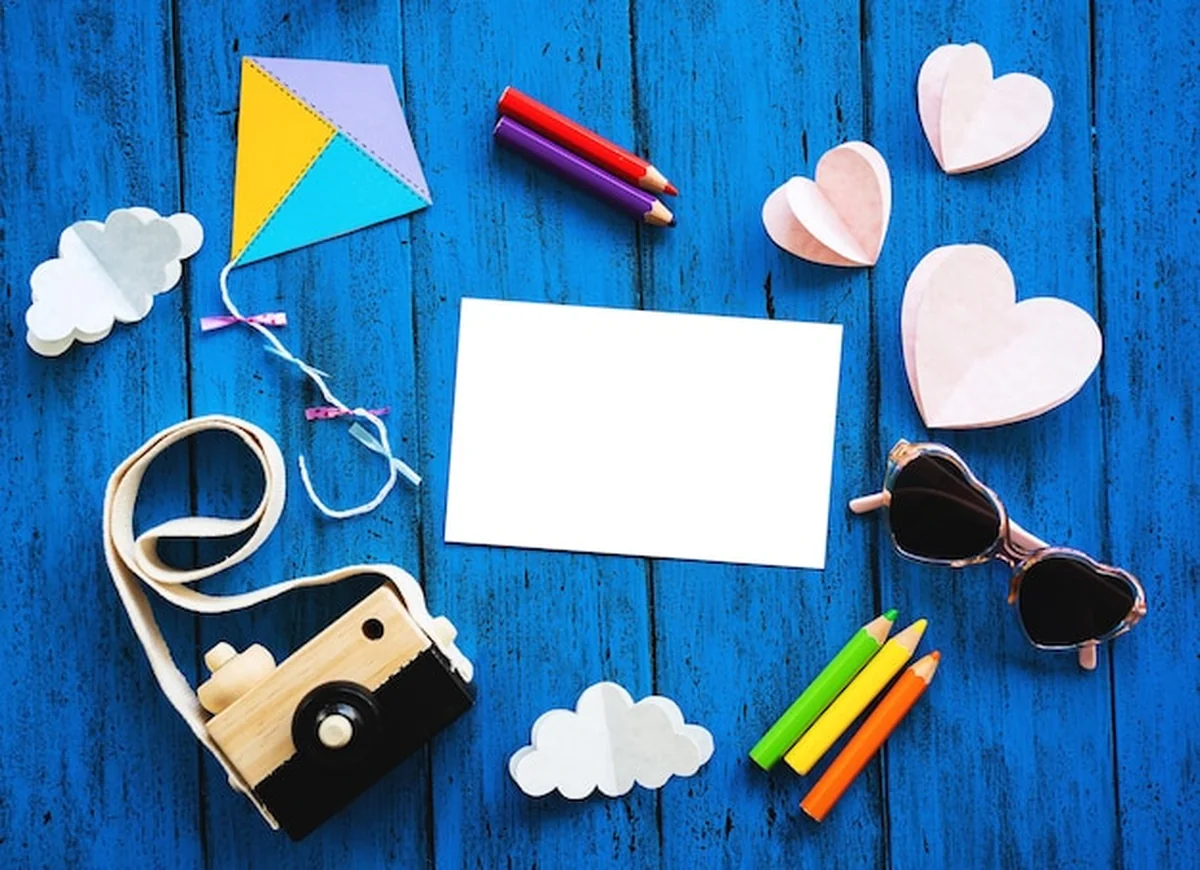 Kreatywne tło dla dzieci z kolorowymi kredkami i aparatem na niebieskim stole