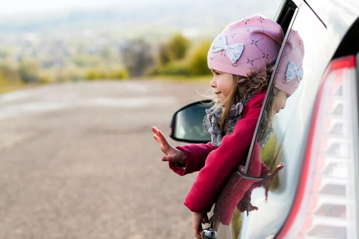 Mała dziewczynka patrzy przez okno samochodu podczas podróży