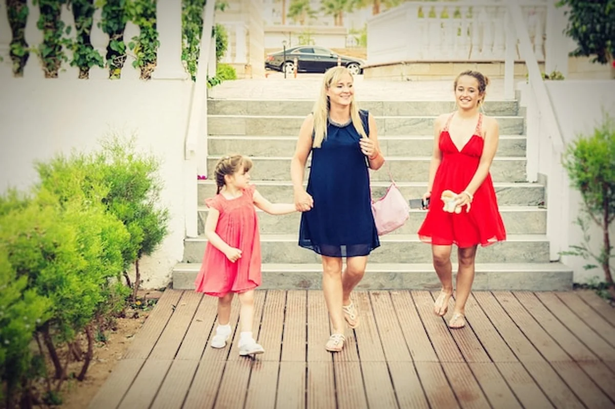 Szczęśliwa kobieta z córkami na schodach