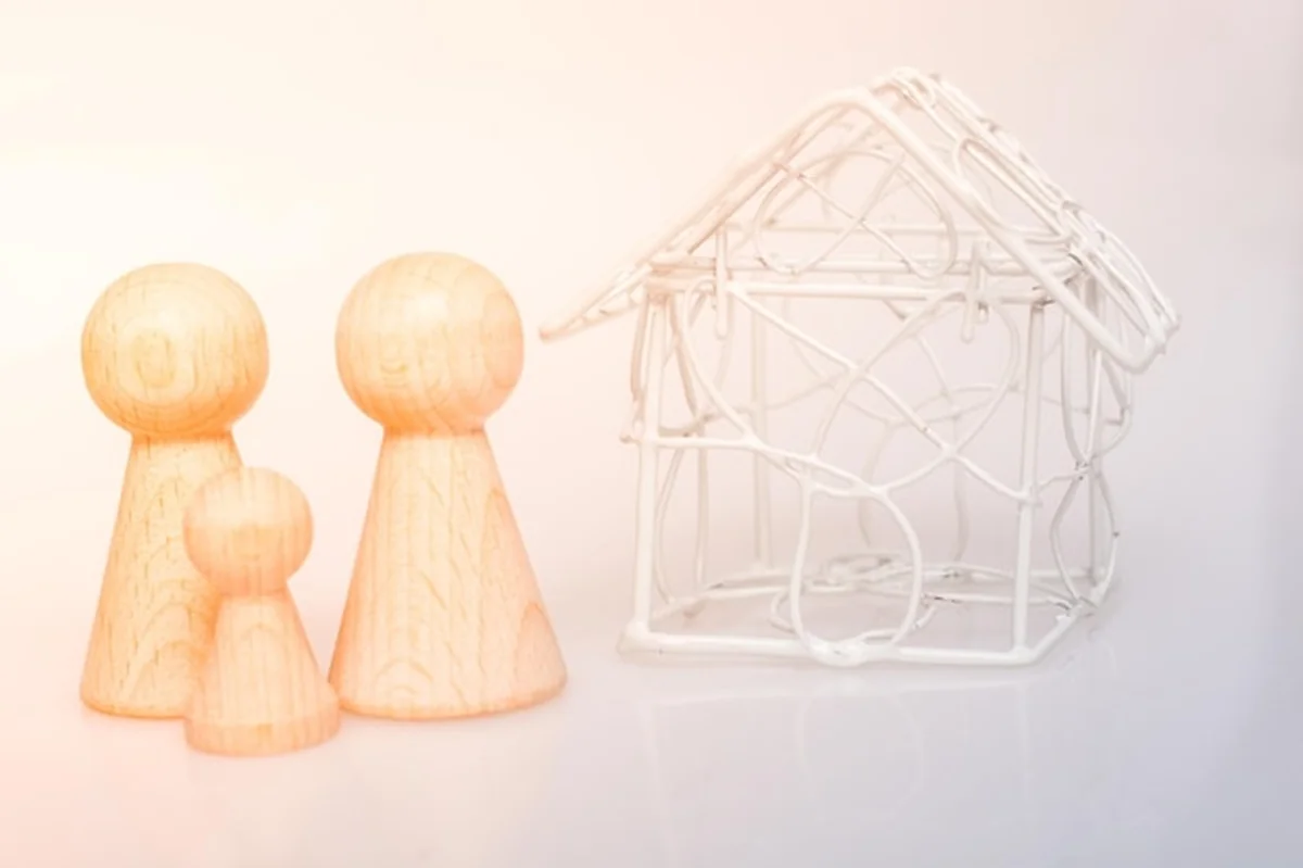 Modelowy dom i drewniane figurki ludzi