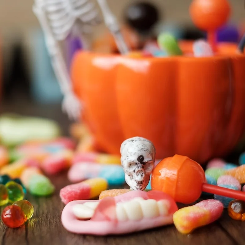 Dynia, miska z cukierkami, lampion Jacka O na tle dekoracji halloweenowej
