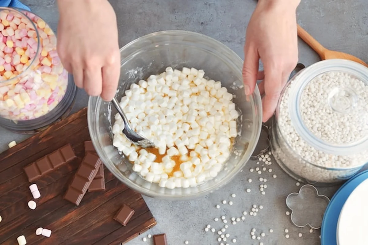 Kobieta mieszająca składniki deseru ryżowego w szklanej misce na stole